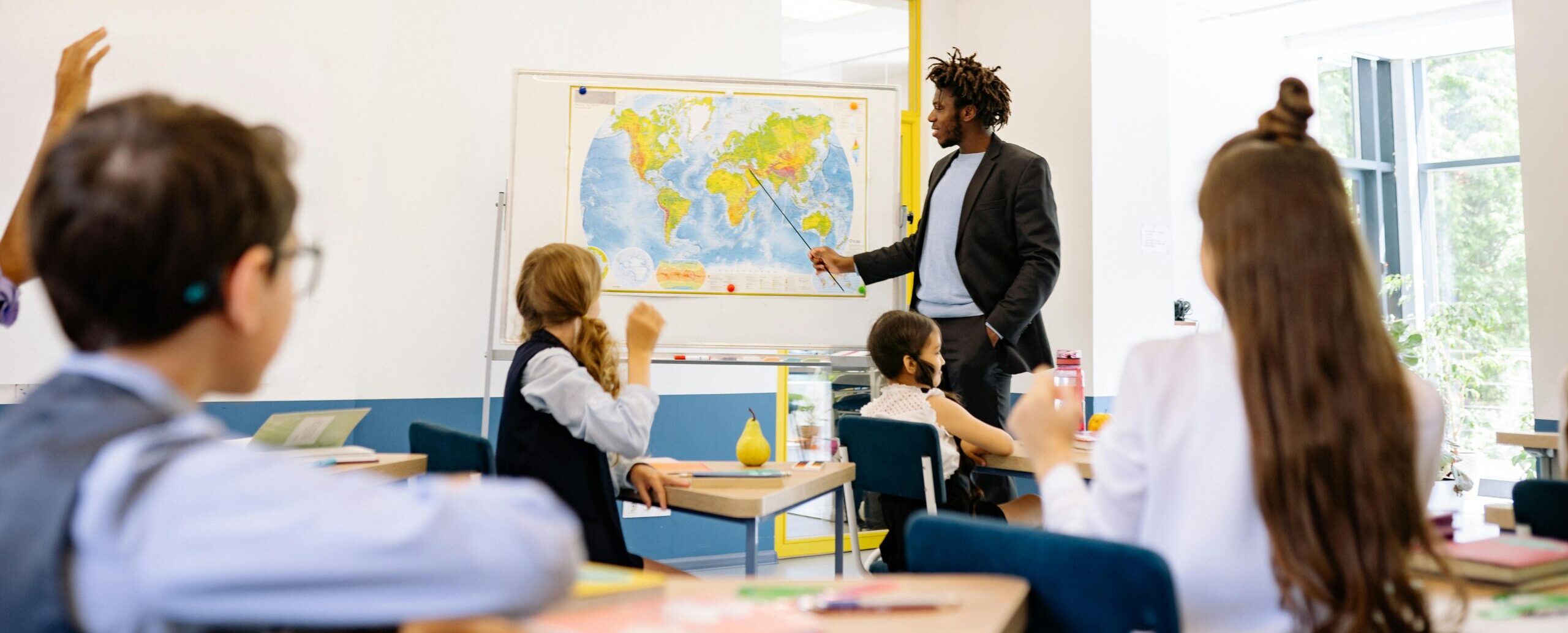 Teacher guiding an interactive classroom session with students responding actively.